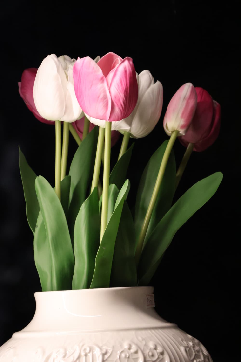 Pink and white tulips in a porcelain vase