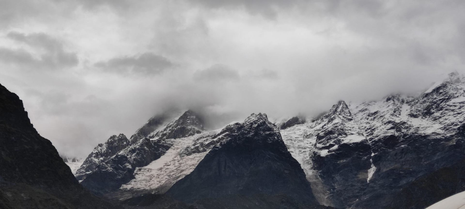 Snow-dusted peaks under heavy cloud cover