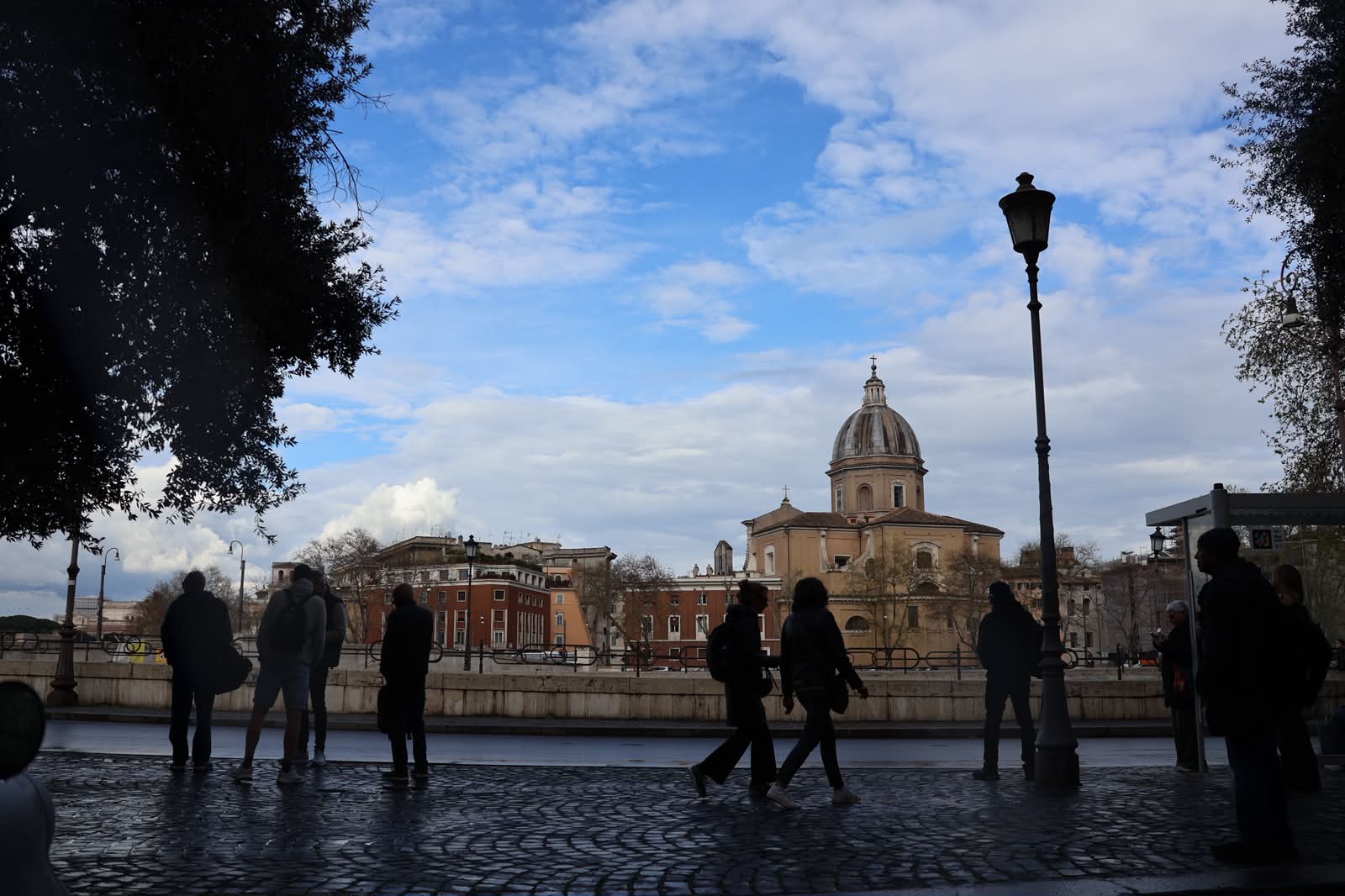 Silhouettes walking past a Roman basilica