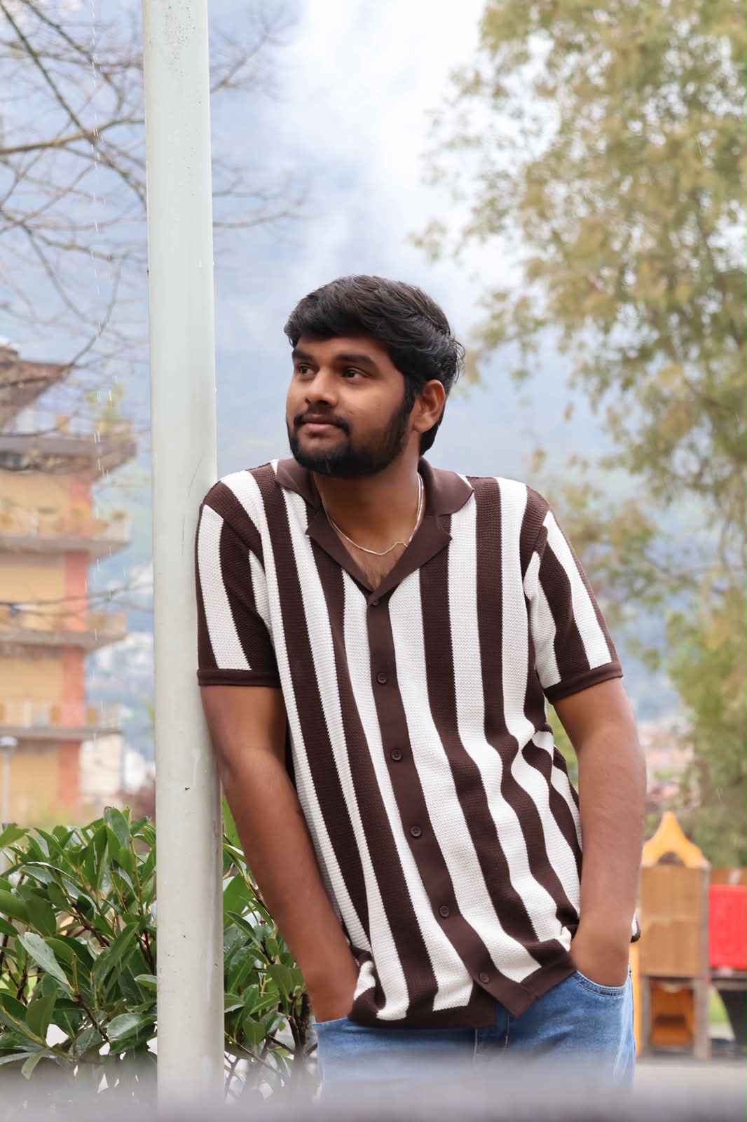 Portrait in striped shirt by a lamppost