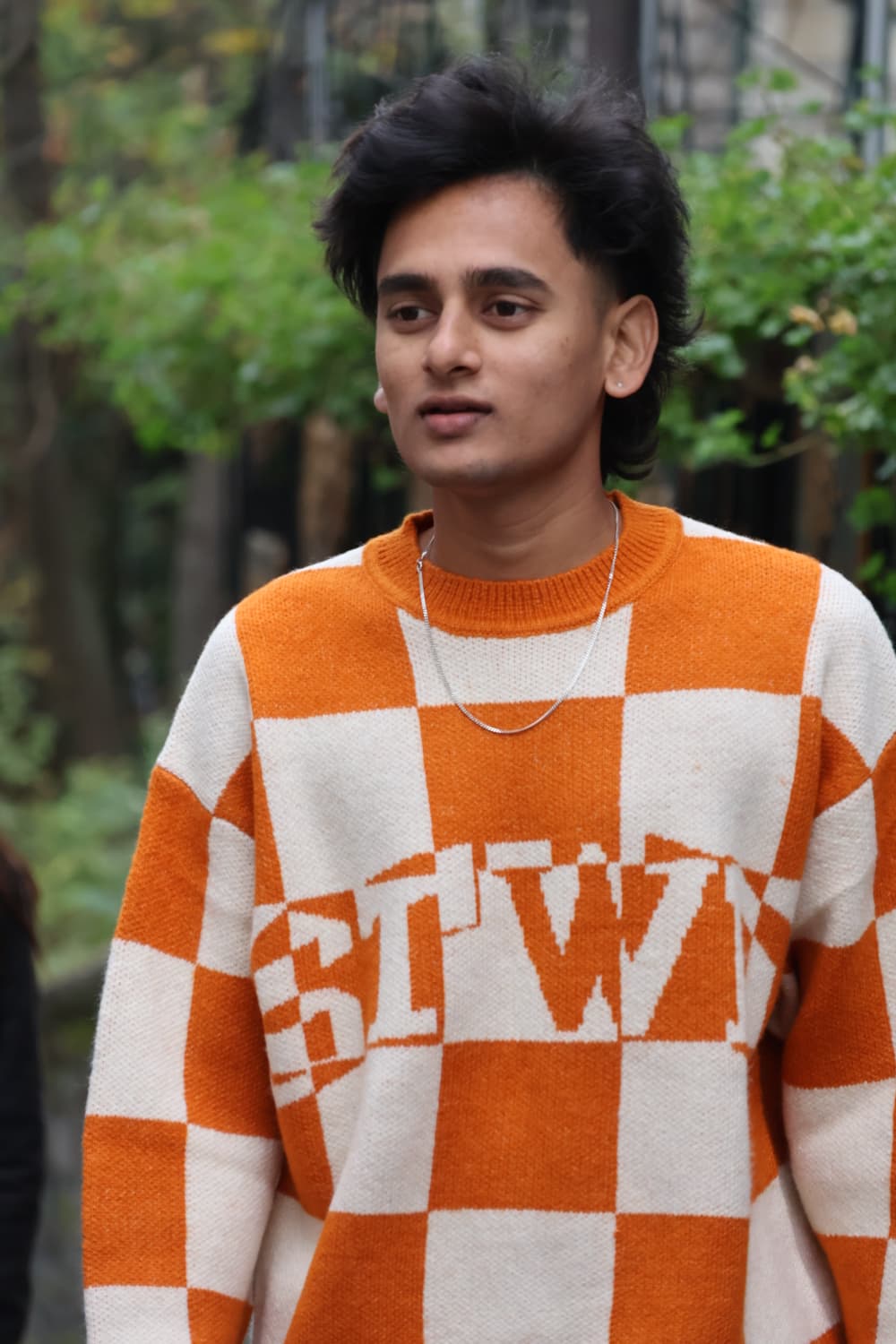 Portrait in orange checkered knit on a Paris street