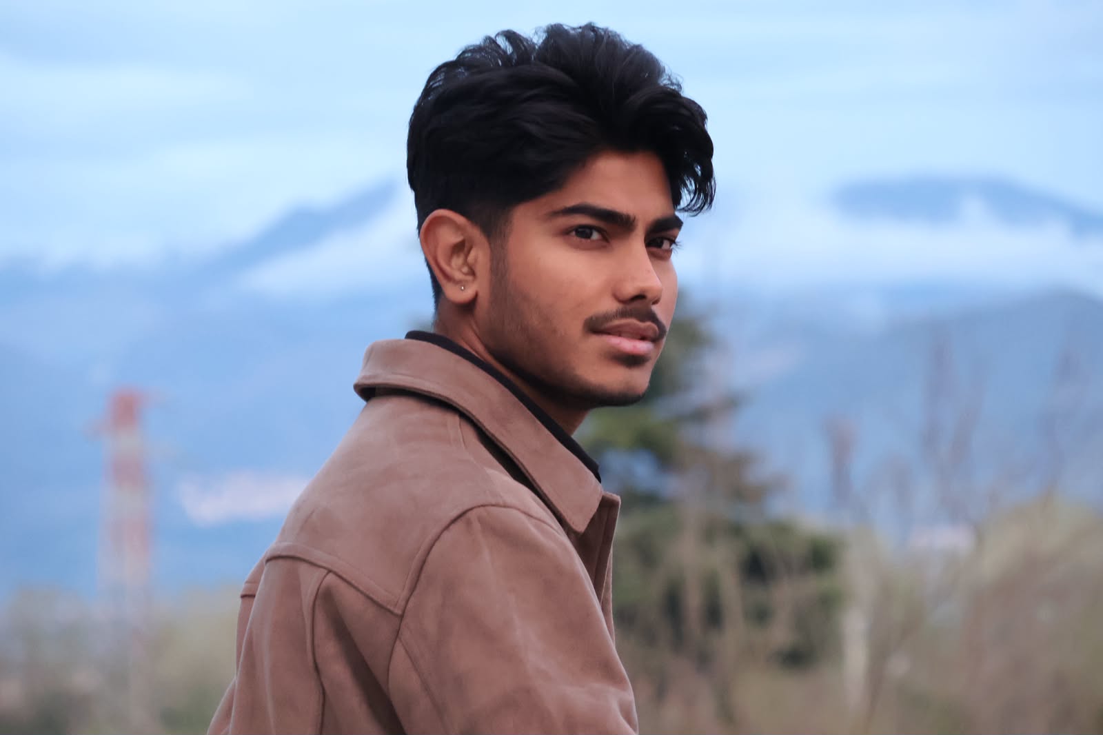 Editorial portrait against misty mountains