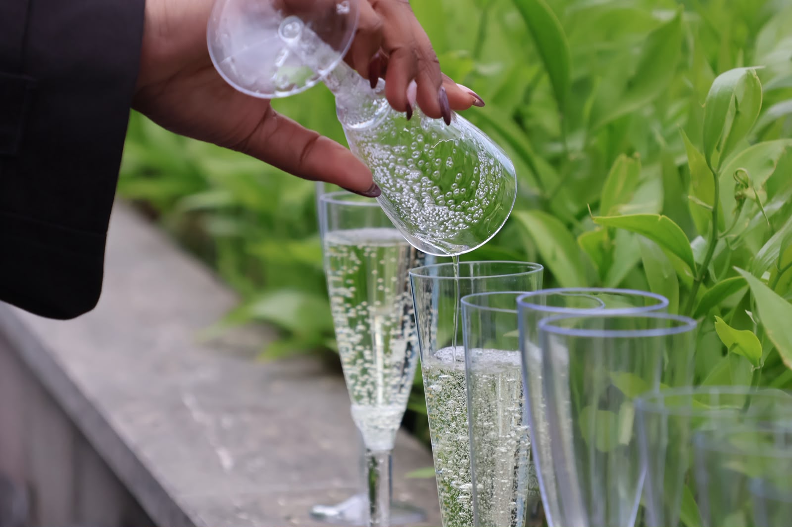 Pouring sparkling wine into glasses outdoors